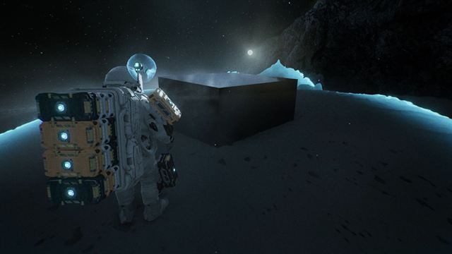 An astronaut carrying stacked modules stands before a black monolith slab