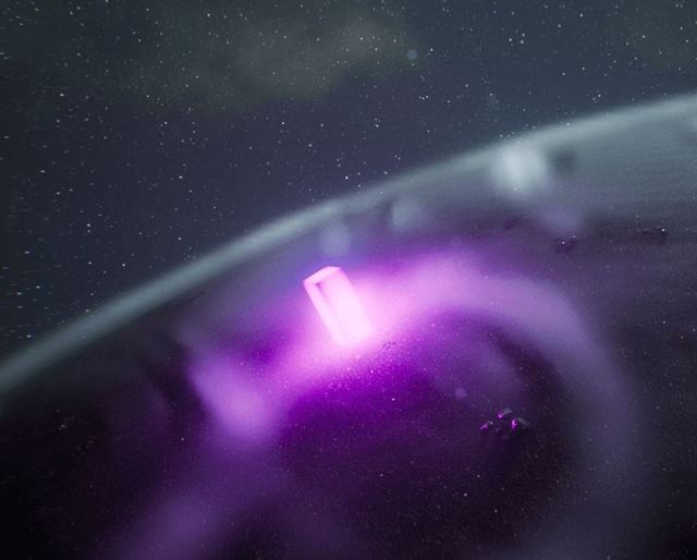 A glowing magenta monolith on a planet surface seen from orbit